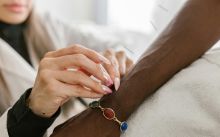 Close-up of acupuncturist inserting needle into arm for pain relief.