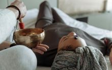 A serene relaxation therapy session with a Tibetan singing bowl and crystal on forehead, promoting spiritual healing.